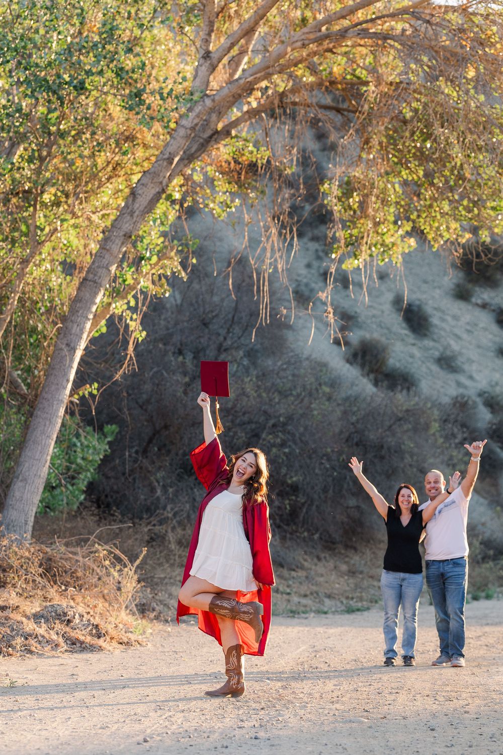 Group having fun at a nature park, doing playful poses and jumping shots among trees during sunset.