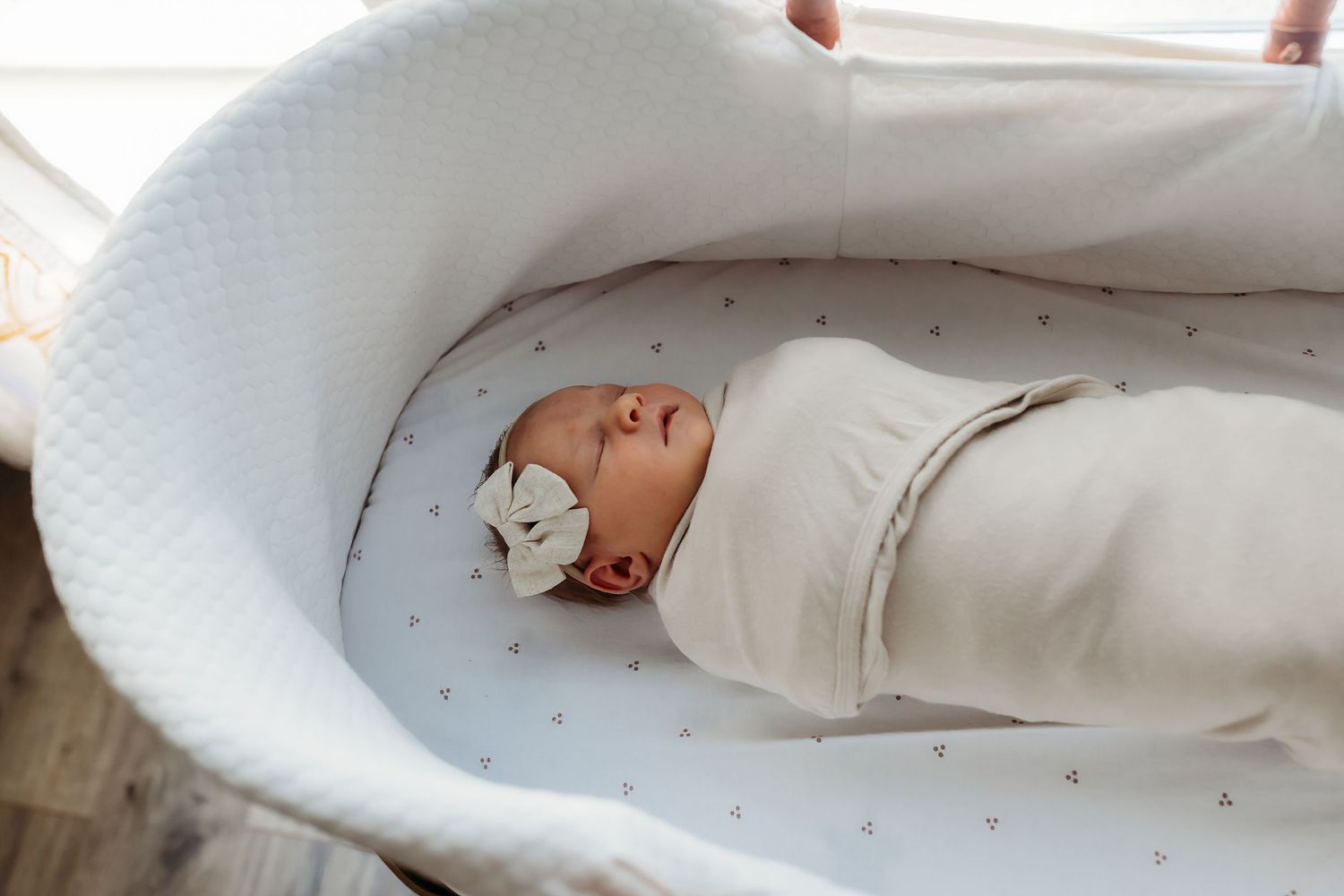 A white baby lounger pillow is shown from multiple angles demonstrating its cushioned design and safety features.