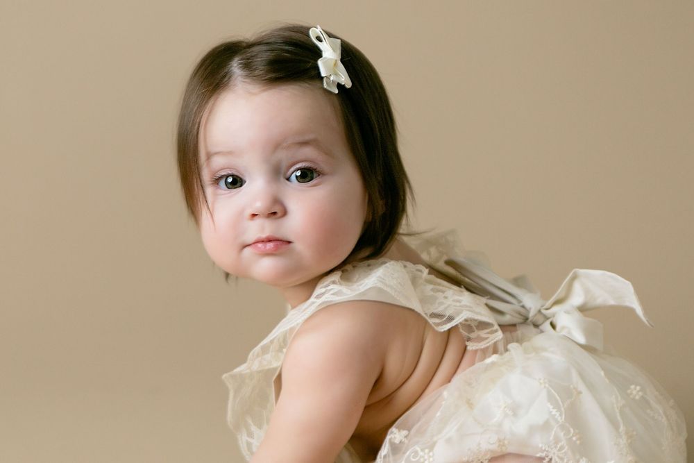 Adorable girl in elegant lace dress with bow, Orlando Cake Smash Photography, Sanford Cake Smash Photography, Orlando Family Photographer