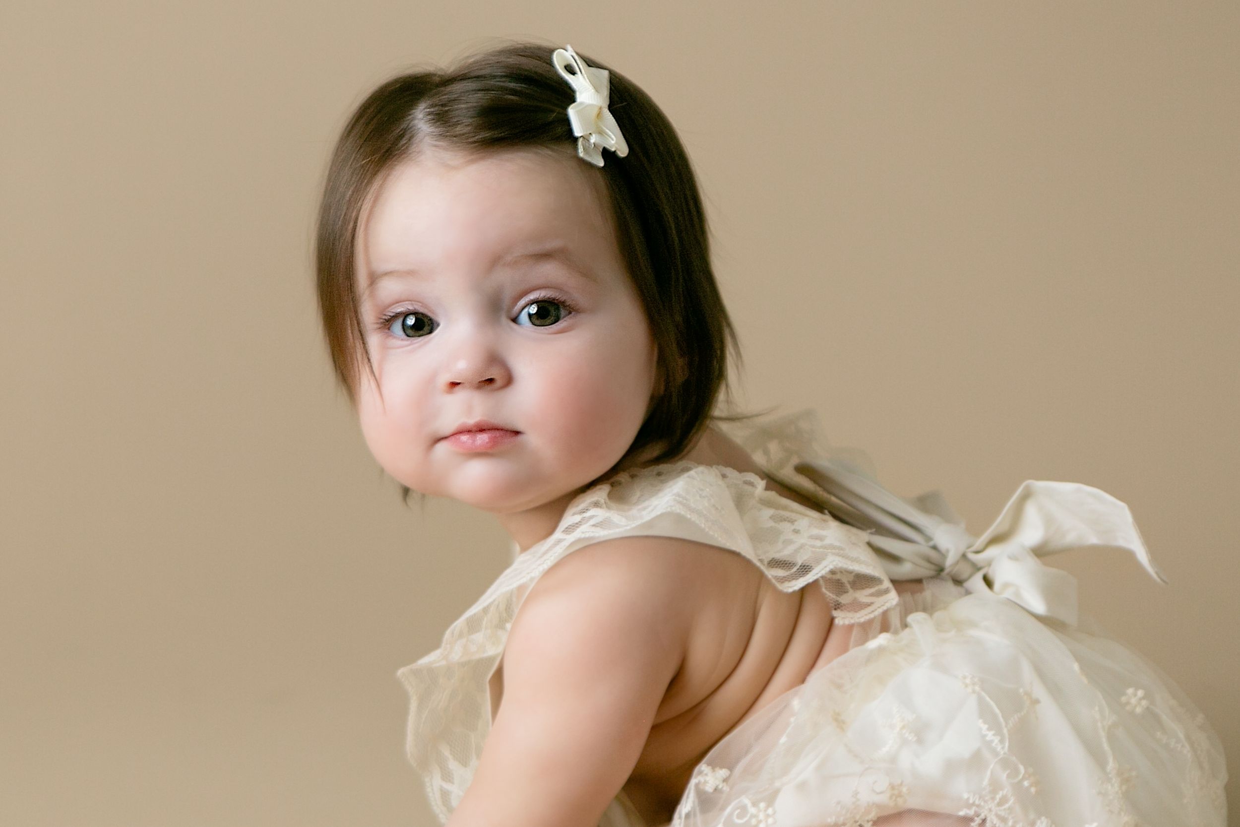 Adorable girl in elegant lace dress with bow, Orlando Cake Smash Photography, Sanford Cake Smash Photography, Orlando Family Photographer