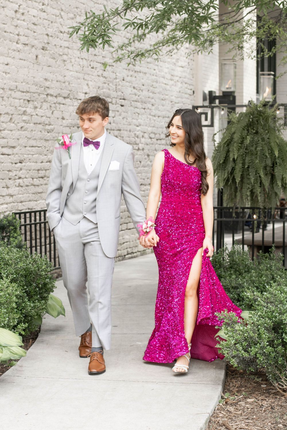 Boyfriend and girlfriend going to prom. Guy wearing a suit. Girl wearing pink prom dress.