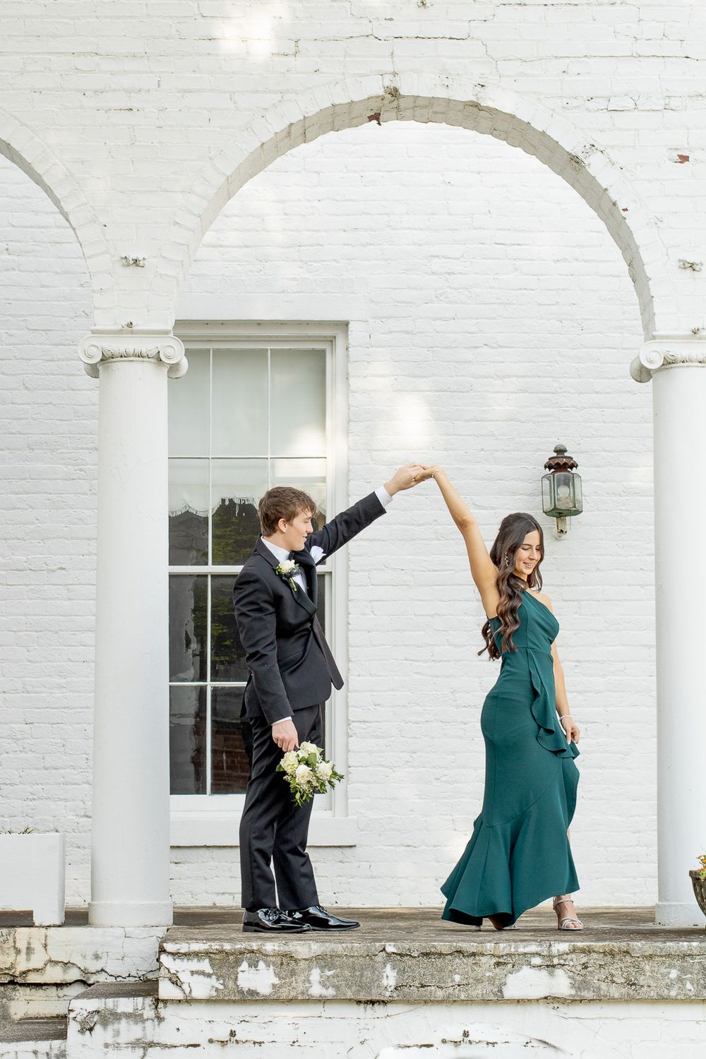 Couple going to prom. Boyfriend spinning girlfriend. Dressed for prom.
