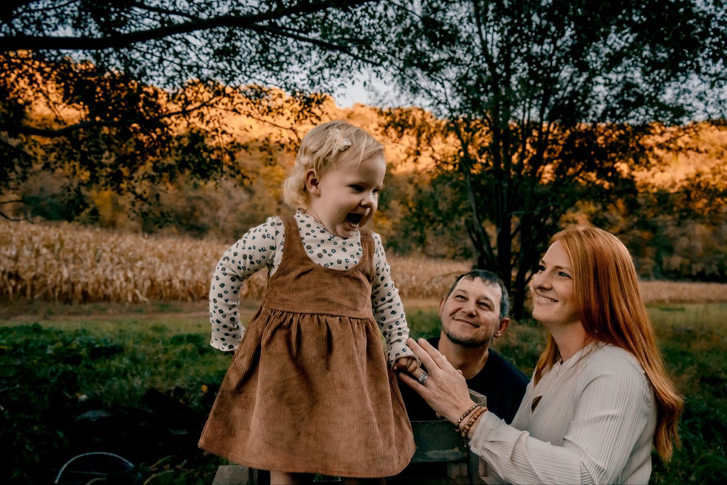 A couple shares tender moments together in a sun-drenched autumn field.