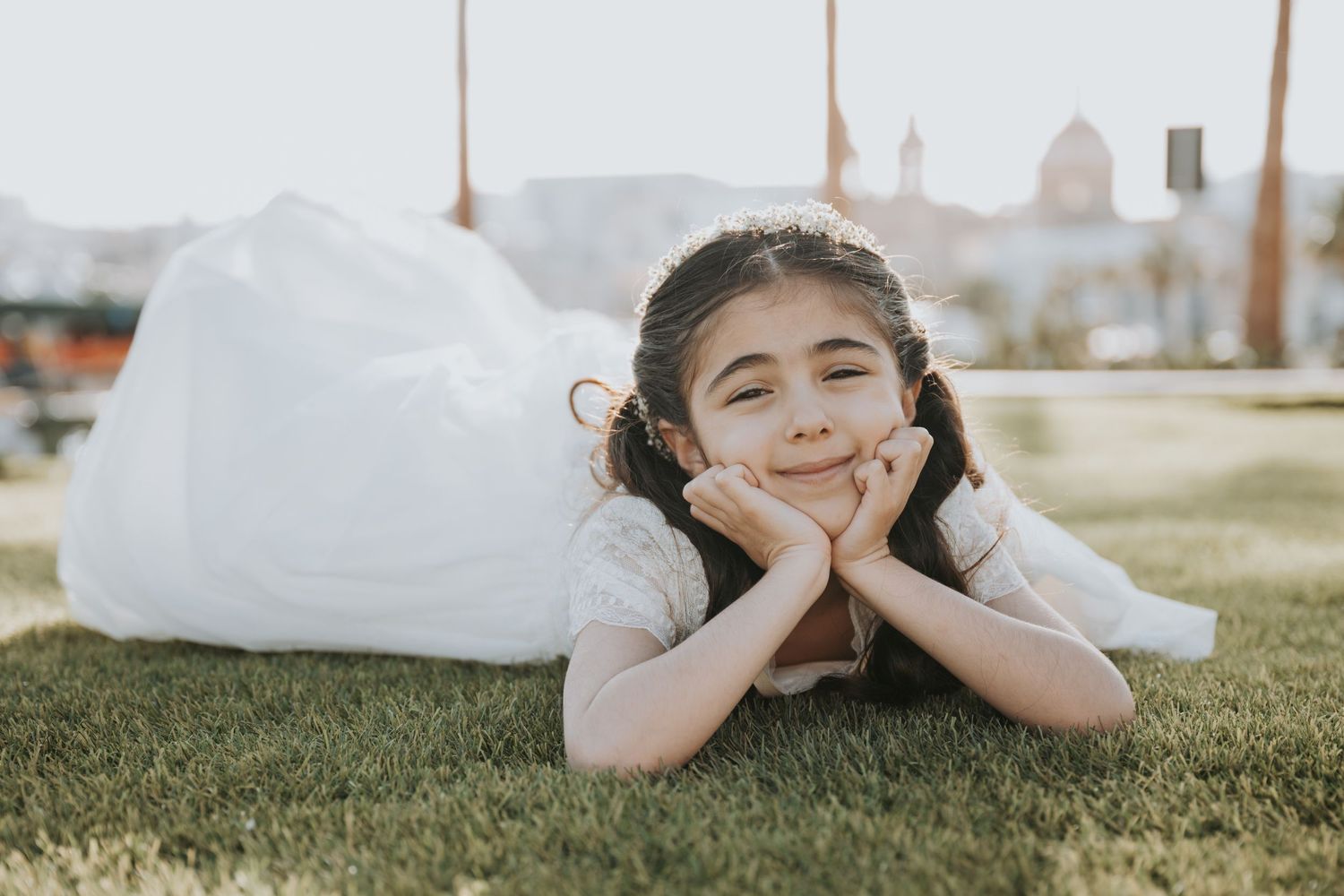 Person in white dress lying on grass during golden hour.
