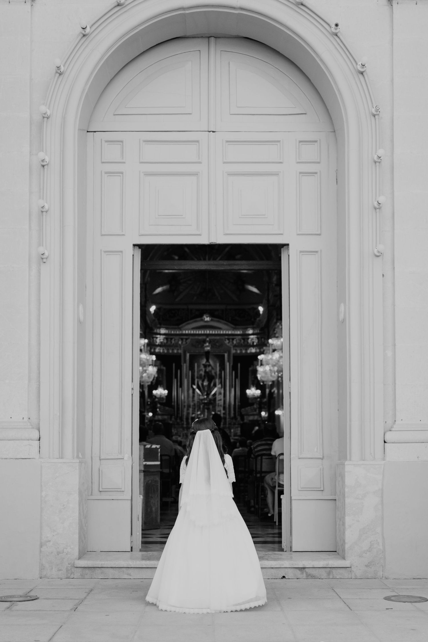 Black and white photo of grand church entrance with arched doorway.