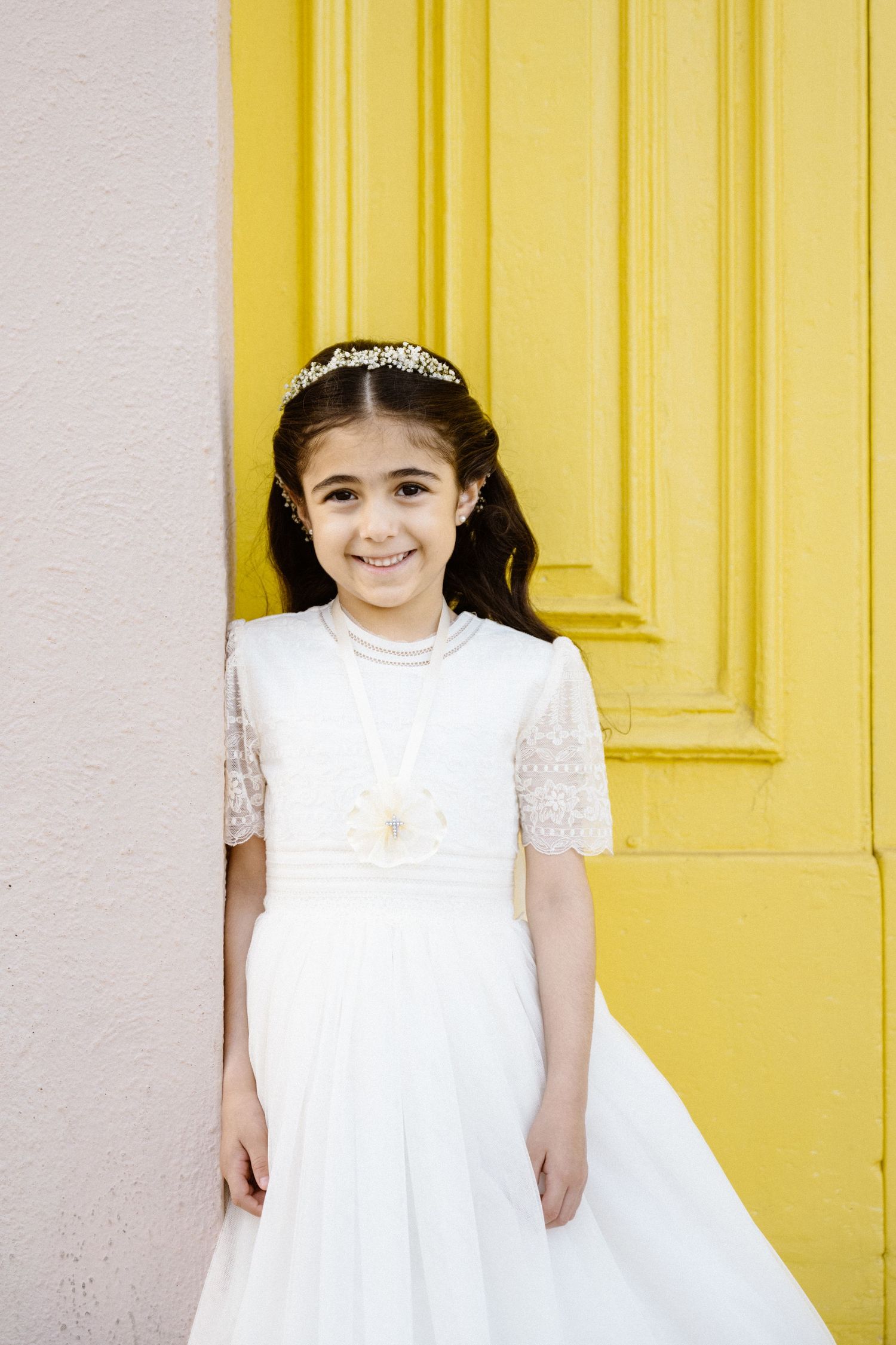 White dress against a bright yellow door creating vibrant contrast.