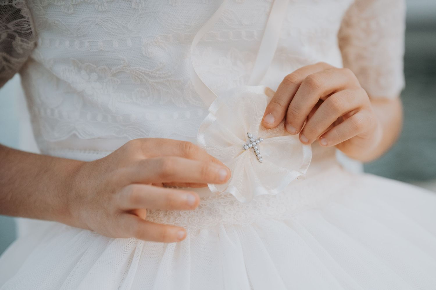 Elegant white lace dress detail with intricate beadwork and embroidery.