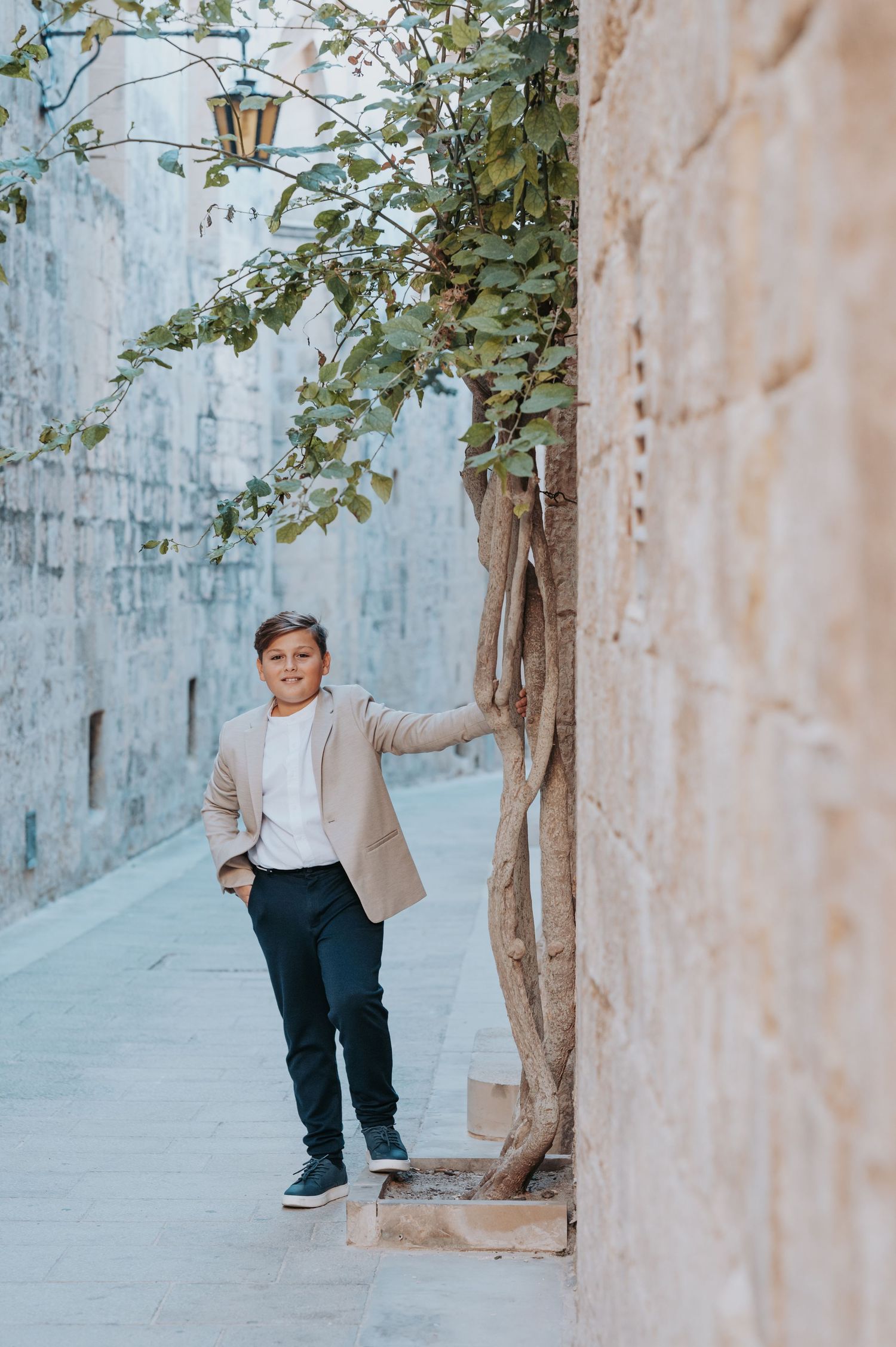 Casual outdoor portraits taken along a stone wall with climbing vines and vintage lamp post.