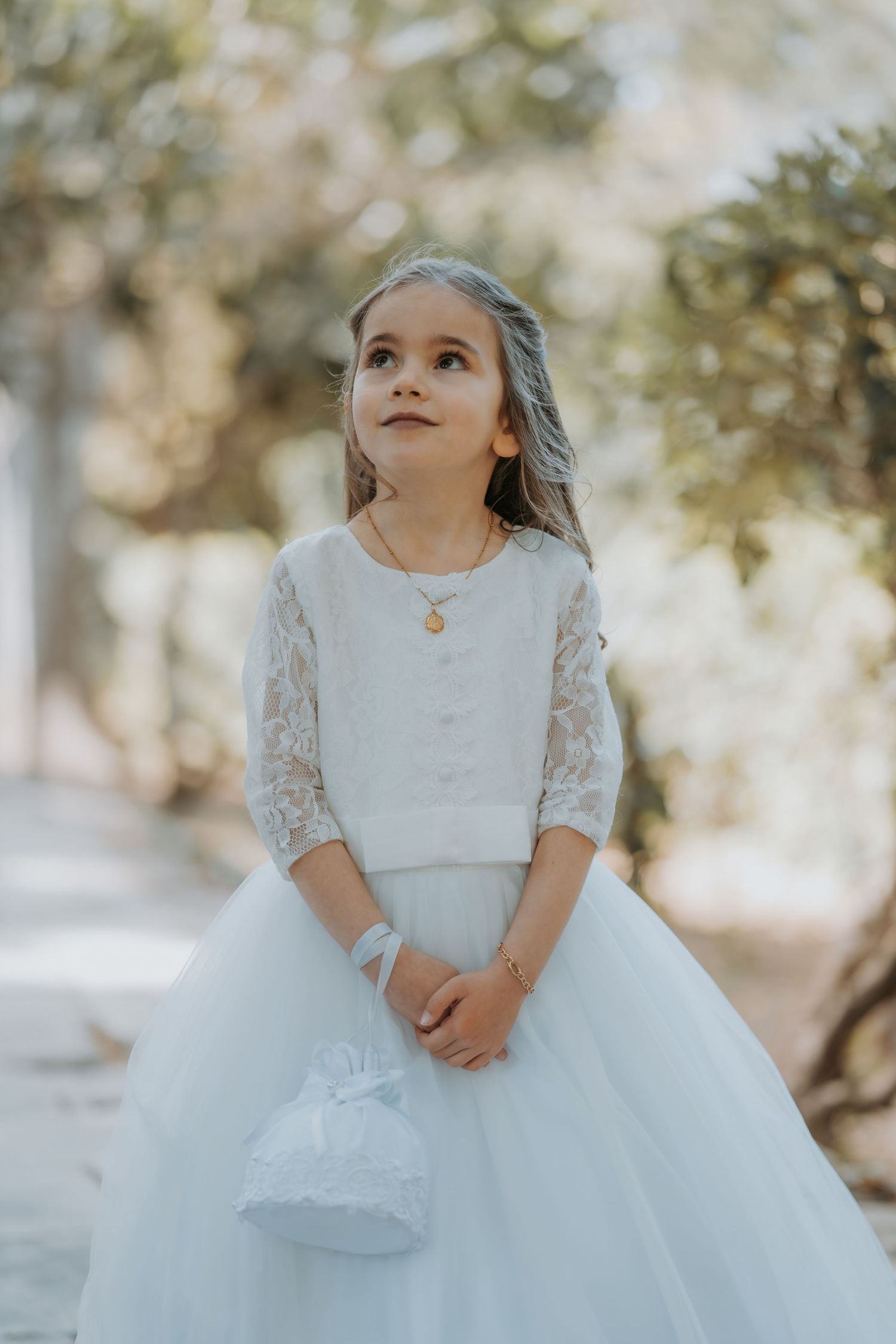 Whimsical portrait series in a white tulle dress against soft natural background.