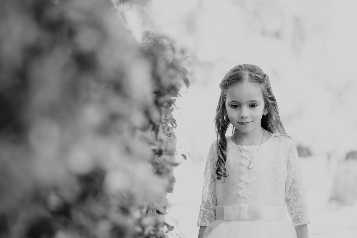 Black and white portrait showing delicate details of special occasion dress and styling.