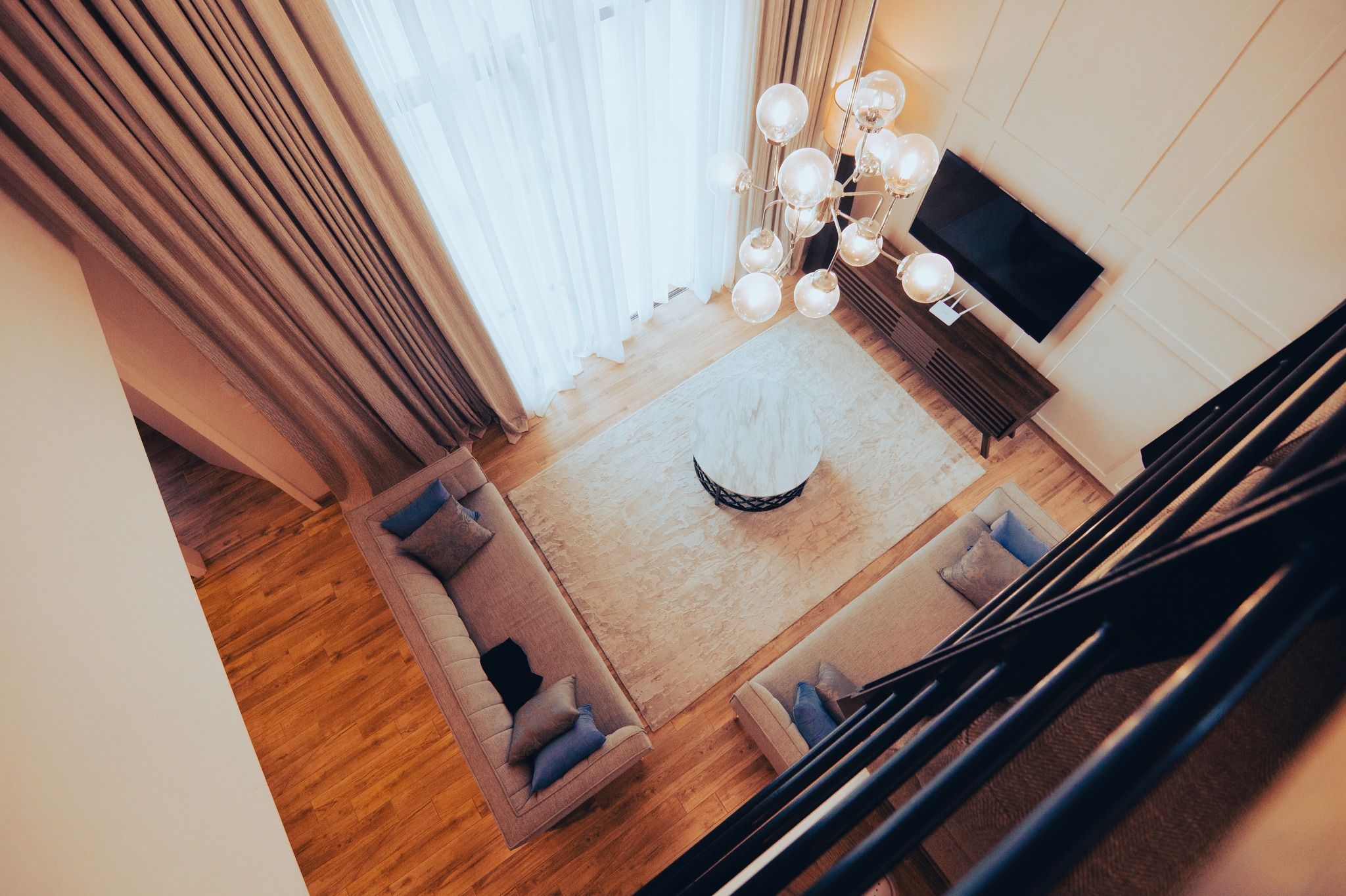 Modern living room interior with white walls and pendant lighting fixtures.