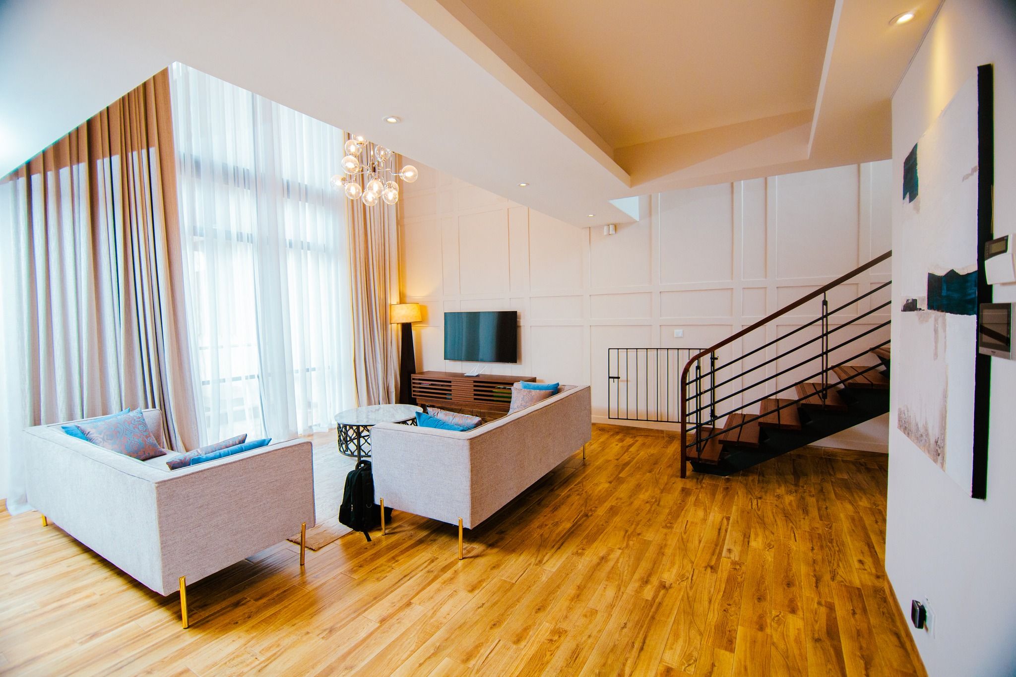 Contemporary living space with hardwood floors and white furniture.