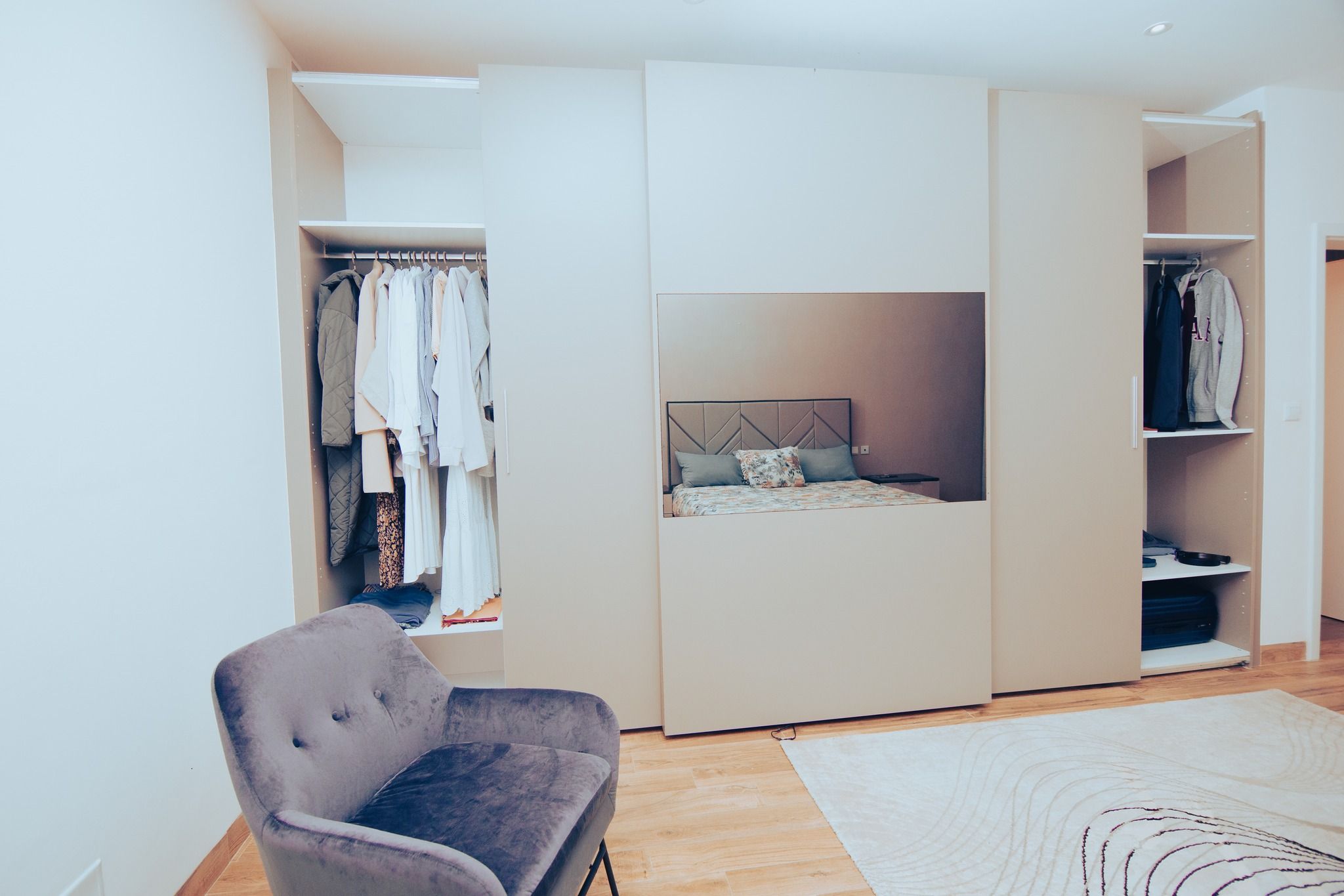 Modern apartment interior with hardwood floors and minimalist furniture in an open concept layout.