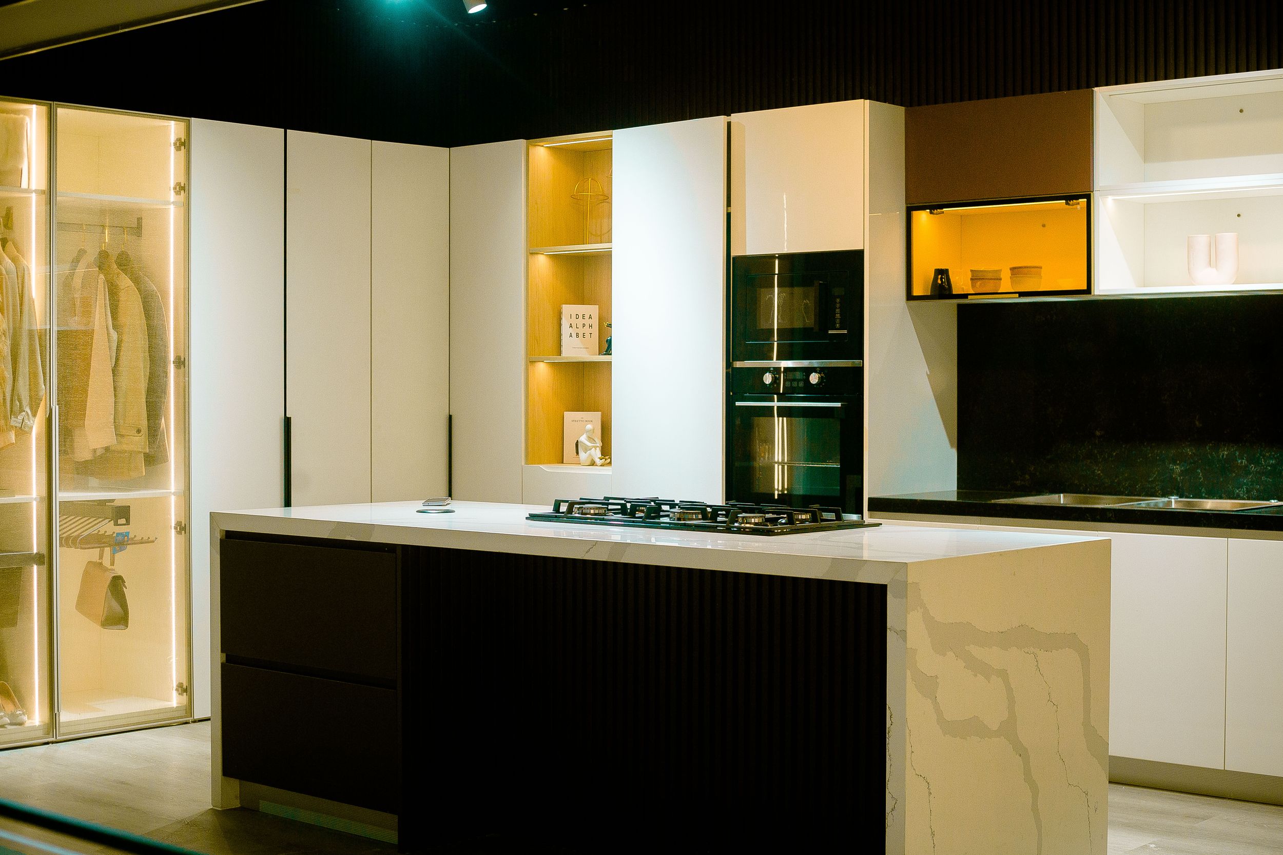 White modern kitchen displays with clean lines and minimalist design in a showroom setting.