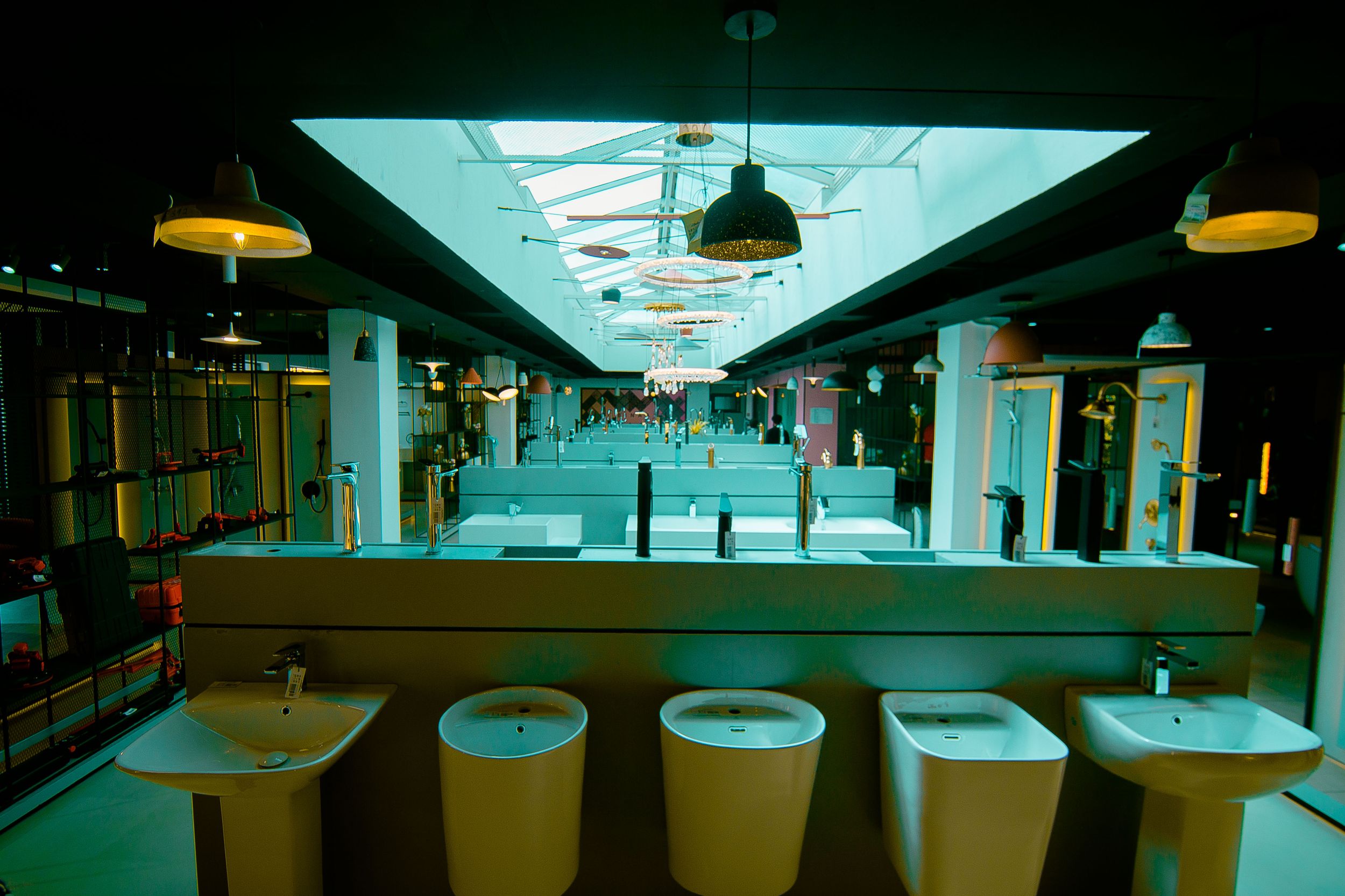 Spacious modern showroom interior with glass ceiling and white display fixtures.