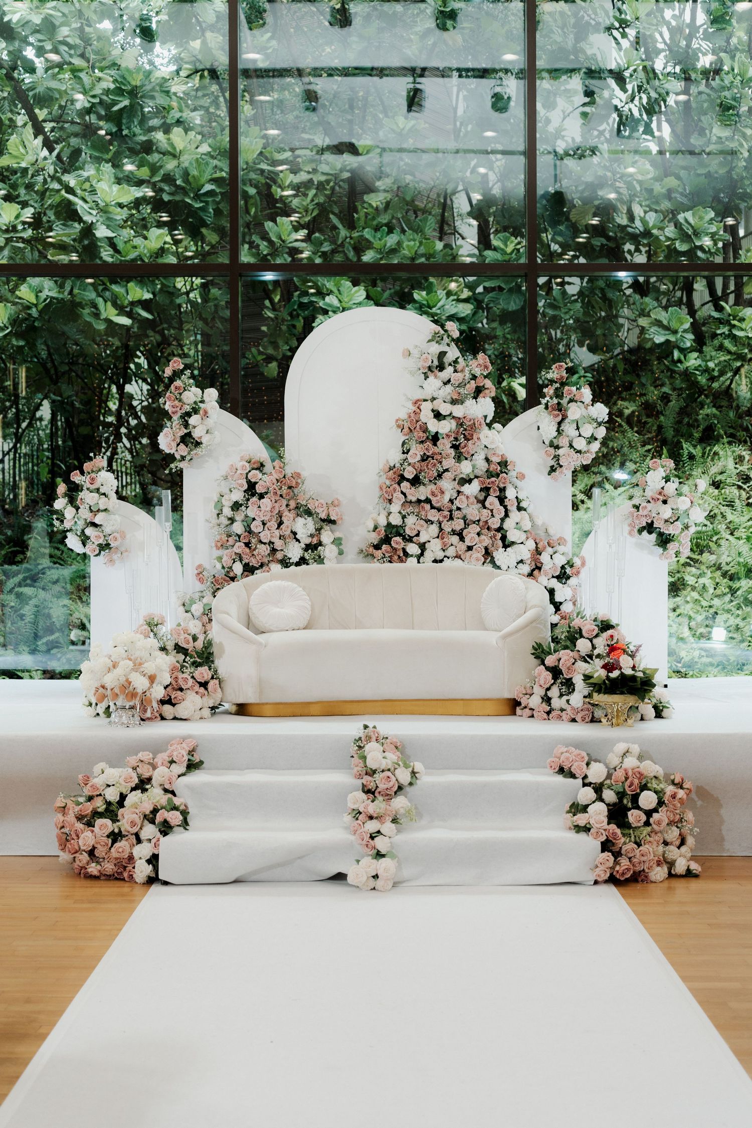 Wedding reception table decorated with pink floral arrangements and white draping.