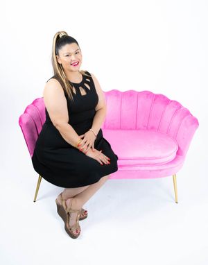 Four fashion poses on a bright pink modern sofa against a white backdrop showcase a black dress outfit.