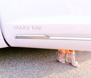 Mary Kay branding visible on white vehicle with pink heels showing underneath.