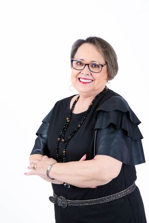 Person in black dress and glasses poses confidently in a series of professional headshots against white background.