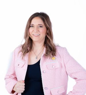 Woman in pink tweed jacket and black top poses in series of professional headshots.