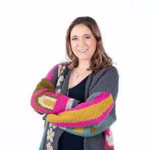 Woman wearing colorful knitted scarf and gray sweater poses in series of casual expressions.