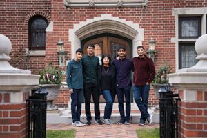 Portrait of family of 5 smiling, standing outside their home - shot by Milwaukee family photographer Rachel Dickman.