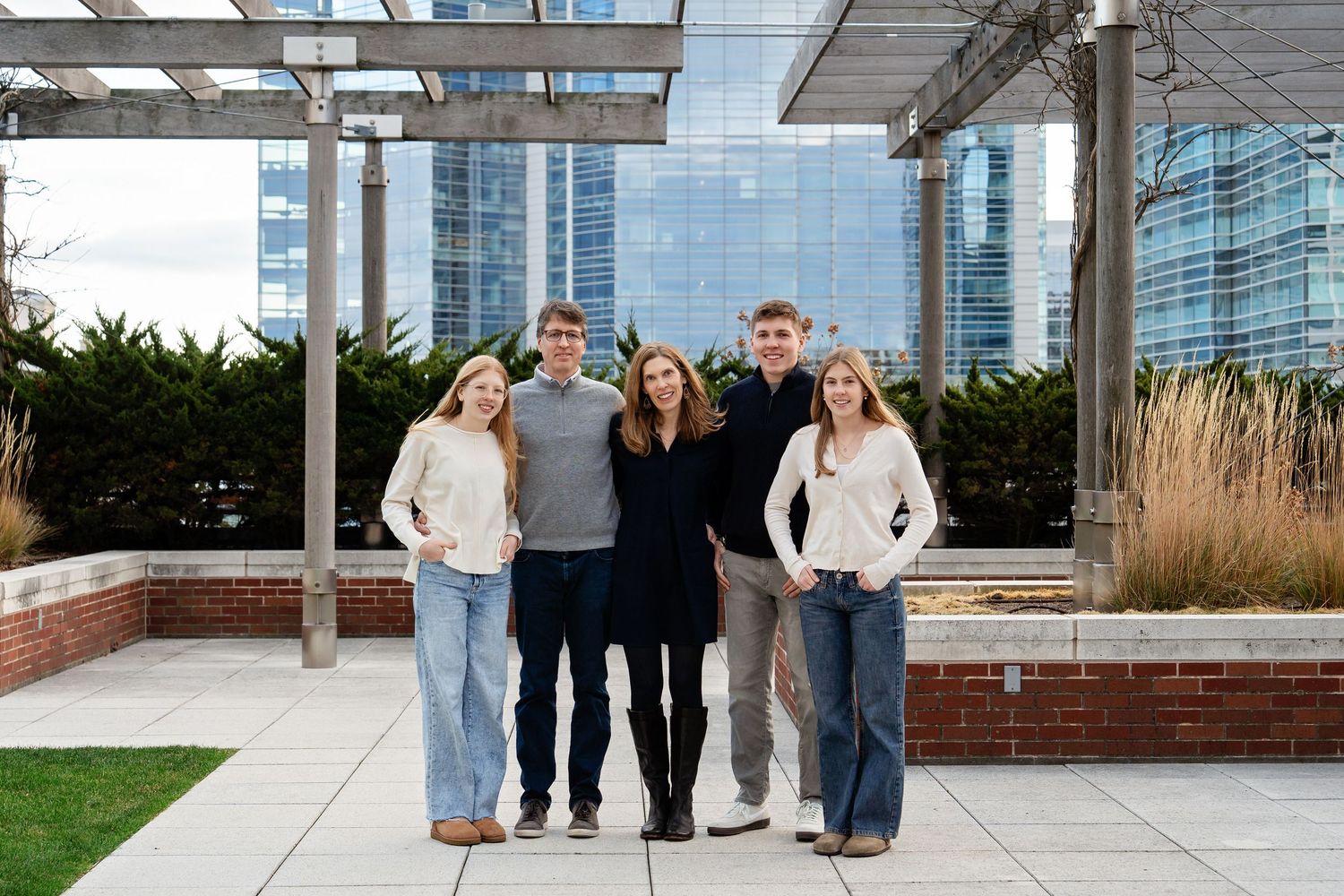 A family standing together under a pergola taken by Milwaukee family photographer Rachel Dickman.