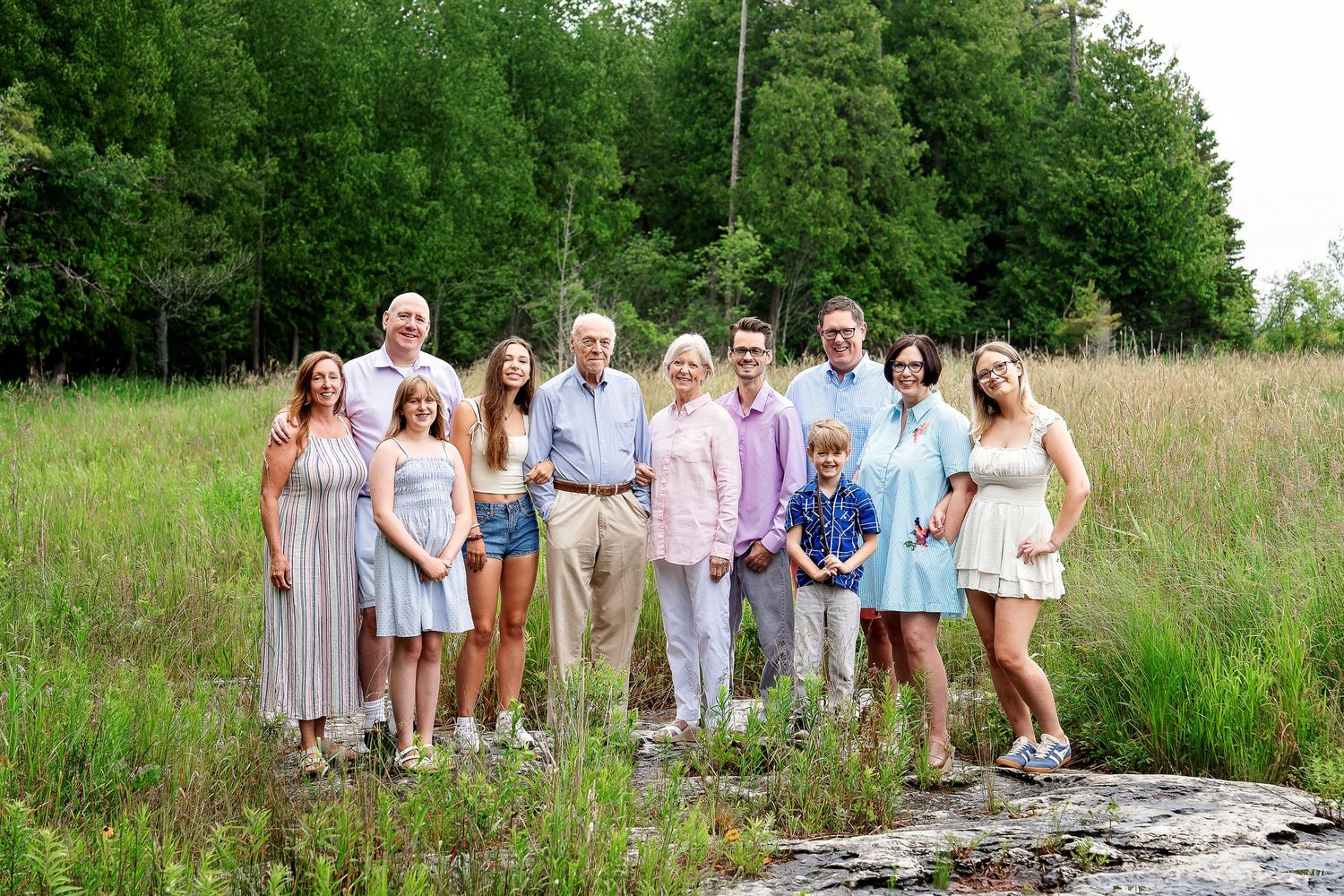 An extended family standing on rocks in a marsh taken by Milwaukee family photographer Rachel Dickman.