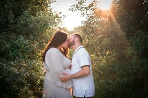 Intimate maternity moment captured between couple at golden hour.