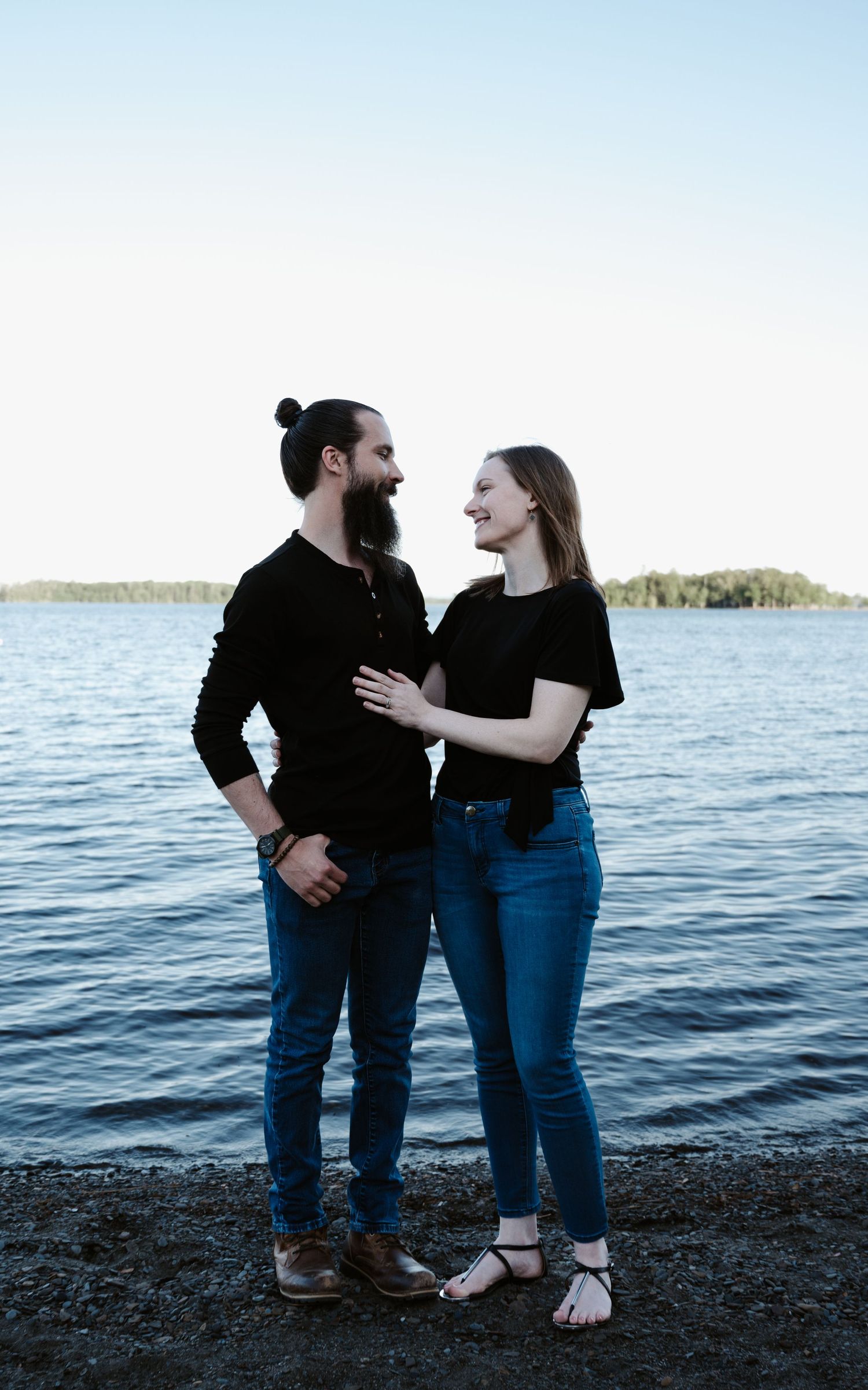 Couple enjoying a romantic moment together by the waterfront at dusk.