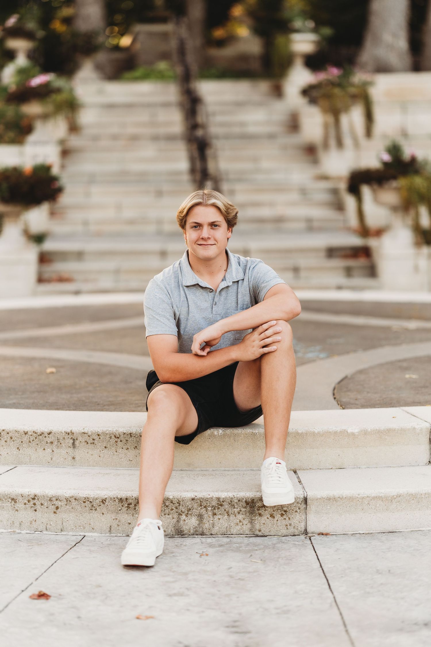 A casual outdoor portrait series showing someone sitting on concrete steps wearing shorts and a t-shirt.