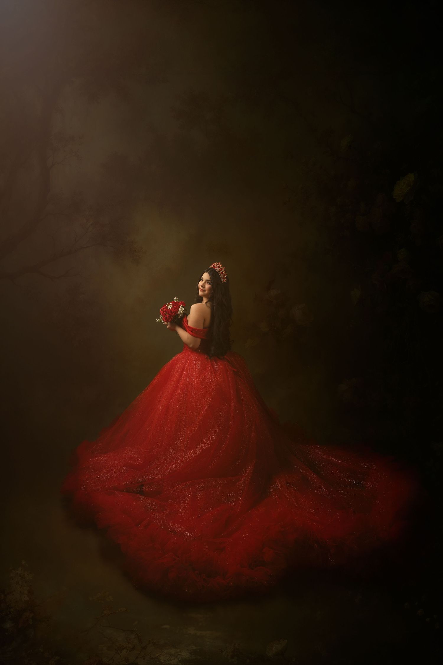 Woman in red ball gown holding bouquet in misty forest.