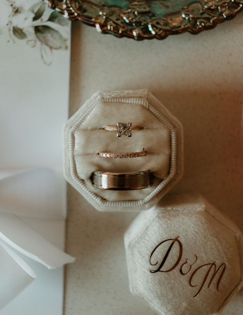 Wedding rings displayed in a velvet octagonal ring box with monogram D&M.
