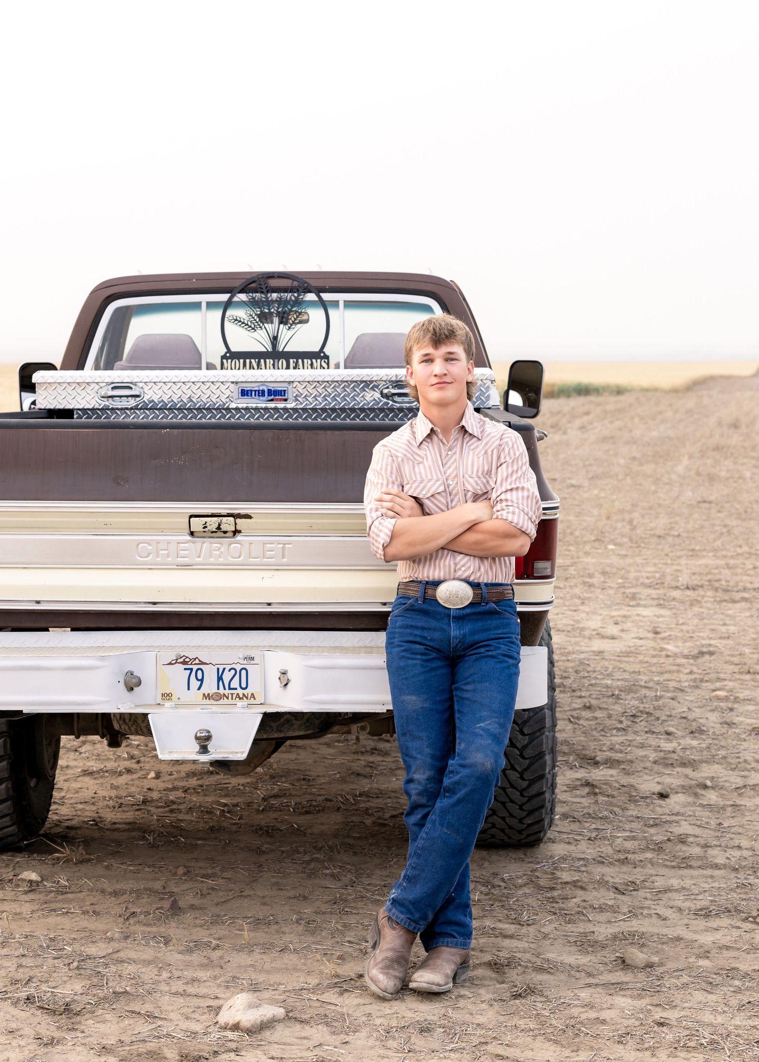 Personalized high school senior boy photoshoot relaxed candid poses next to favorite truck Montana Chouteau County Fort Benton Great Falls