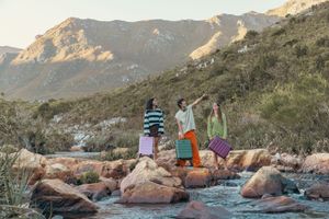 Group enjoying outdoor adventure among rocks and mountains near water.