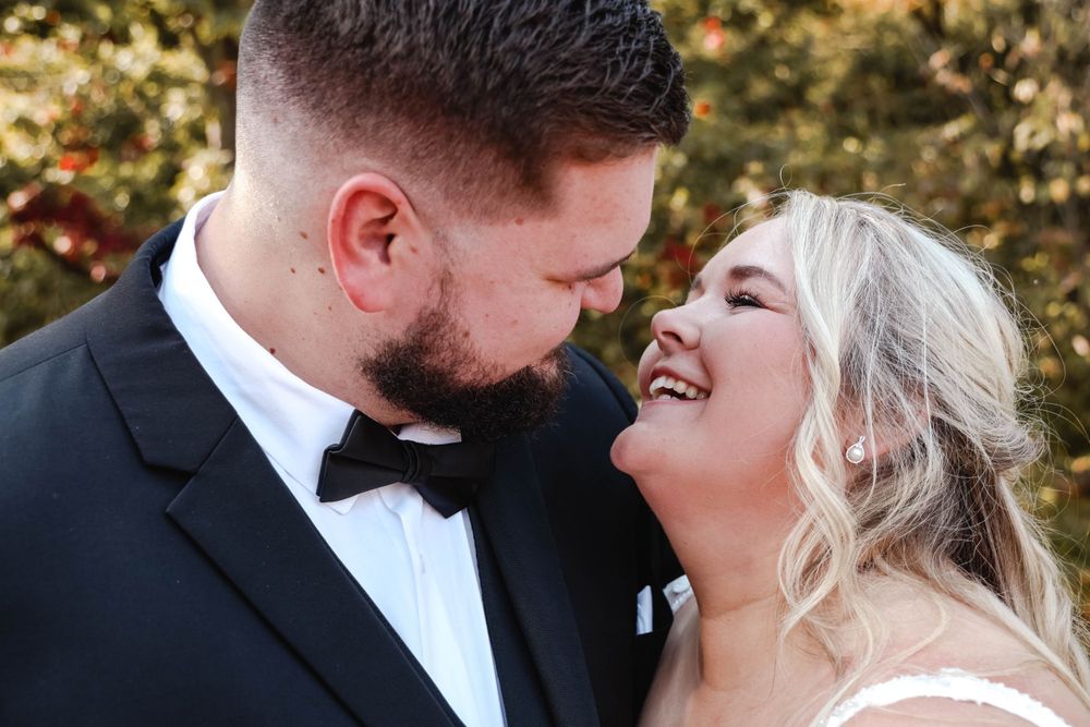 An intimate black and white wedding photo capturing a joyful moment between newlyweds.