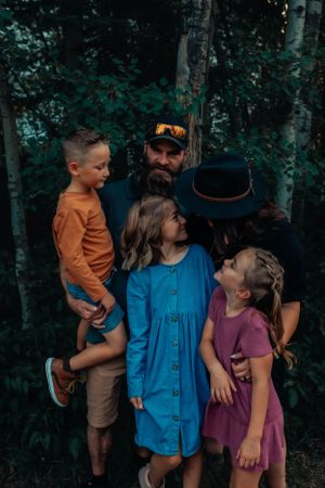 Candid family moment captured in forest setting with natural expressions.