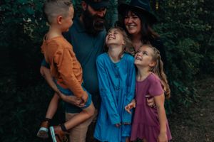 Candid family moment showing laughter and joy in forest setting.