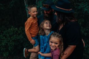 Casual family portrait showing playful interaction outdoors.