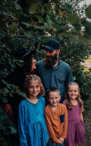 A group portrait taken among leafy foliage with natural lighting.