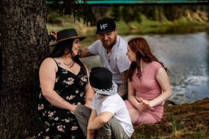A family shares intimate moments while relaxing outdoors in nature.