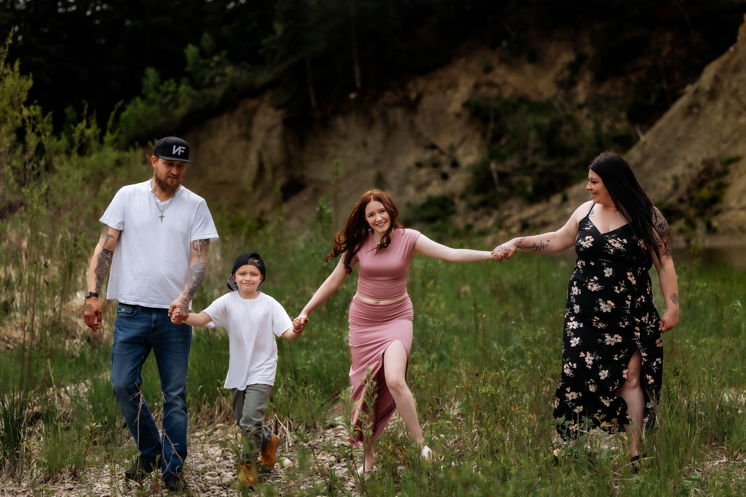 A playful family photo session in a grassy field during golden hour.