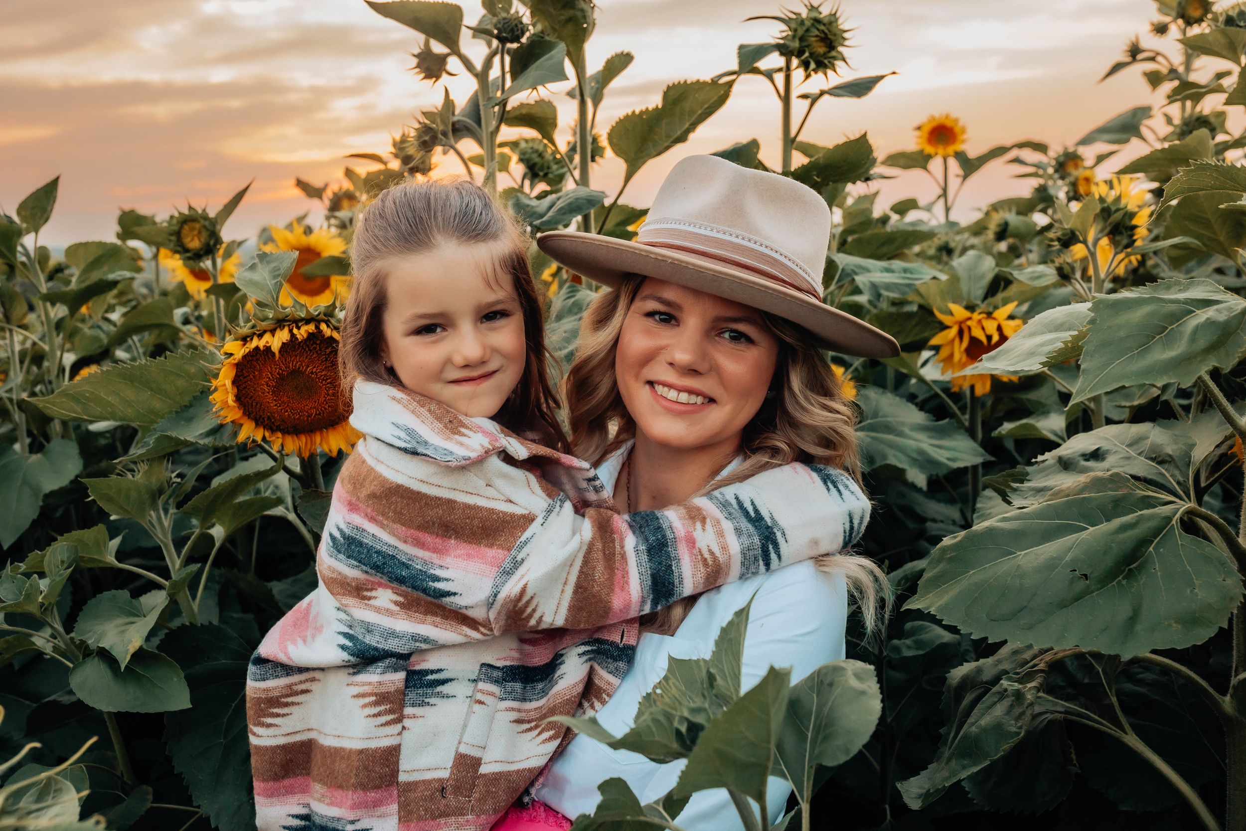 Candid family interactions photographed in sunflower field at sunset.