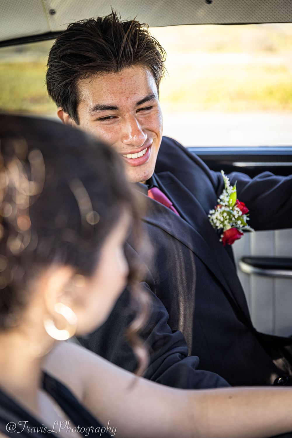 Formal occasion inside a vehicle with boutonniere visible.