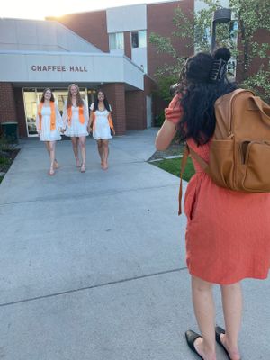 A photo of Brenna taking grad photos of a group of graduates