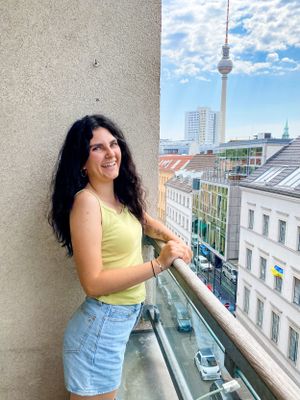 A photo of Brenna on a balcony with a view of Berlin