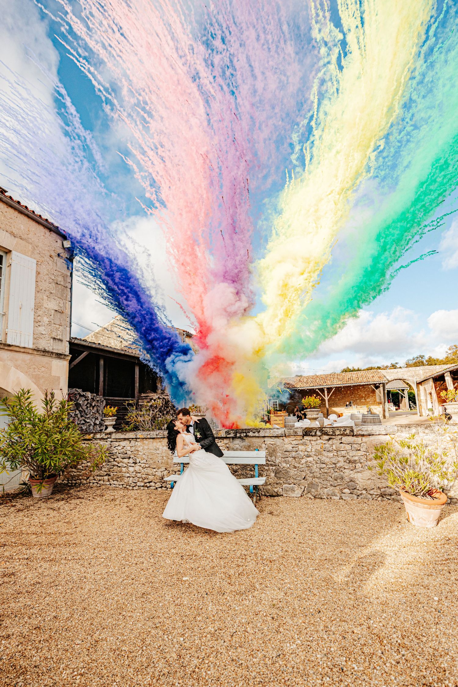 Mariage élégant à Oléron. Couple s'embrassant sous les fumigènes / feux d'artifices colorés de jour.