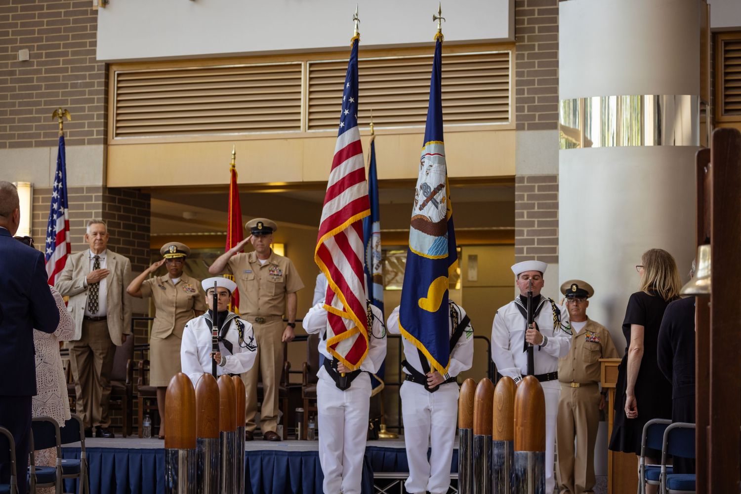 Professional military ceremony of a U.S. Navy Color Guard in Dress Whites presenting the American and Navy flags indoor