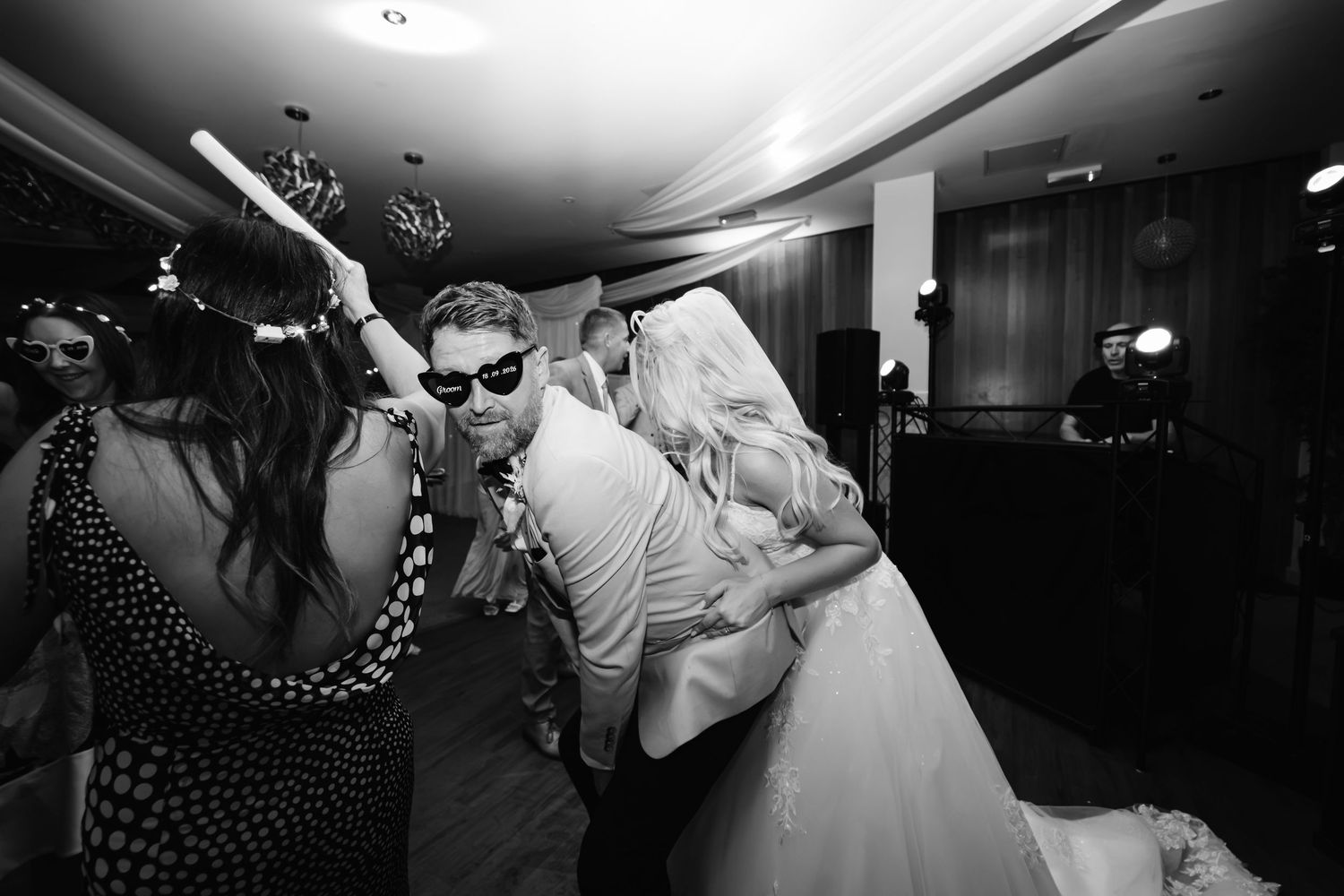 Black and white photo of bride and groom kissing on the dance floor at their wedding.