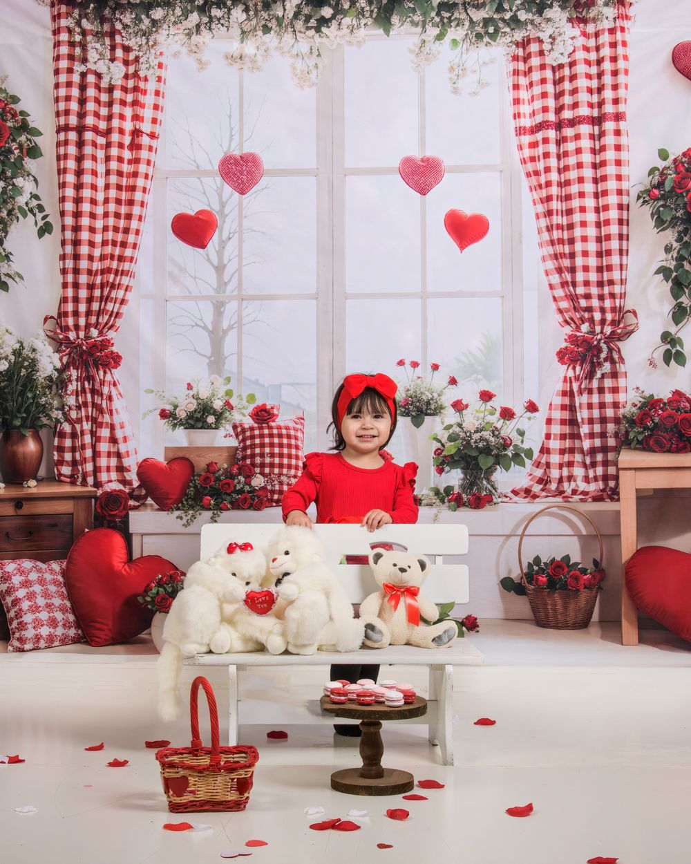 Romantic Valentine's Day photo studio setup with red and white gingham curtains, hearts, and scattered rose petals.